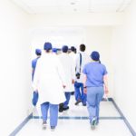Surgeons and hospital leaders walking through a sterile white hallway