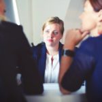 Two recruiters interviewing a young woman applying for a job.