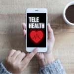 person holding phone with screen that says telehealth
